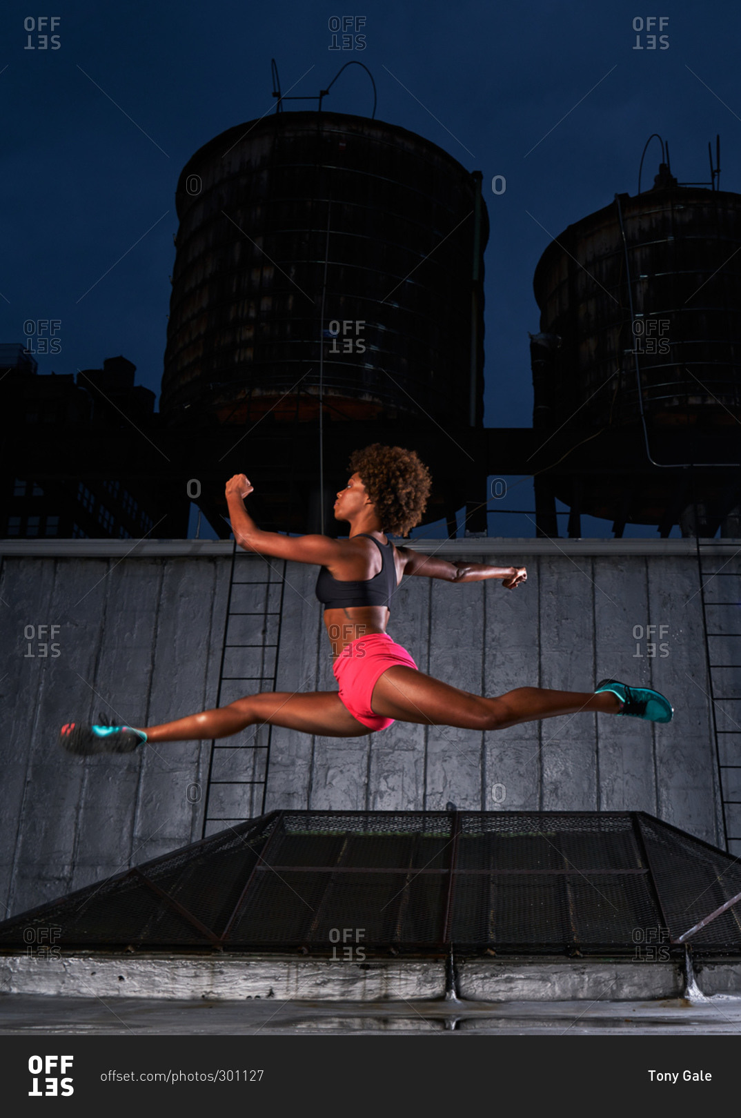 Athletic dancer leaping on a rooftop