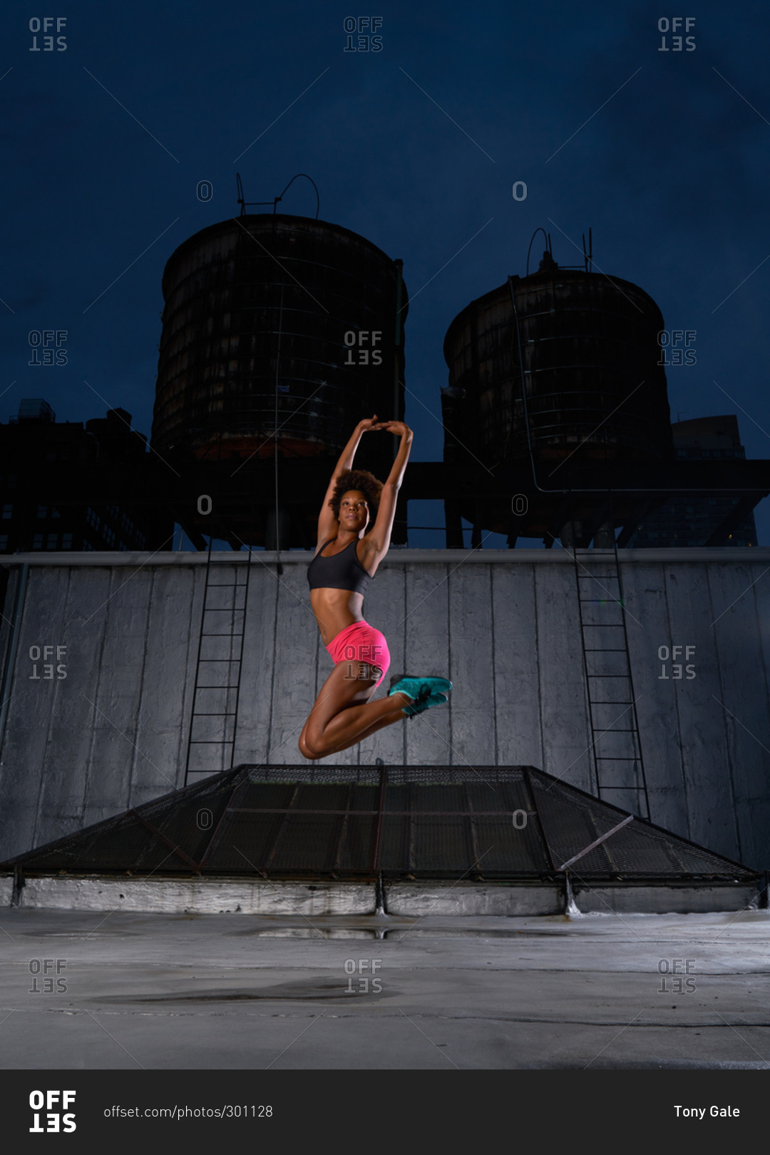 Athletic dancer jumping on a rooftop