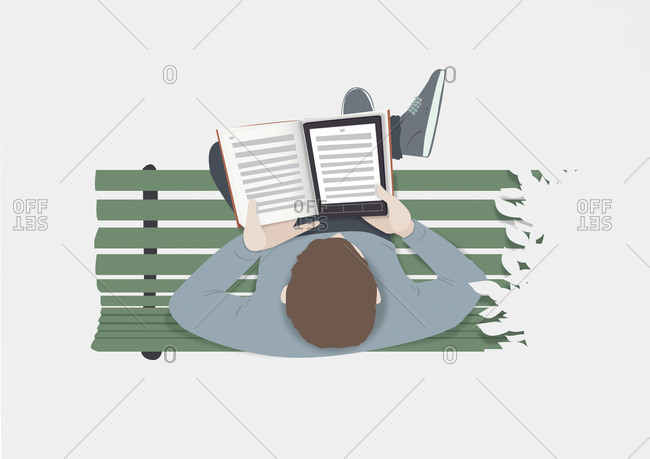 Man sitting on a park bench reading a tablet inside a book