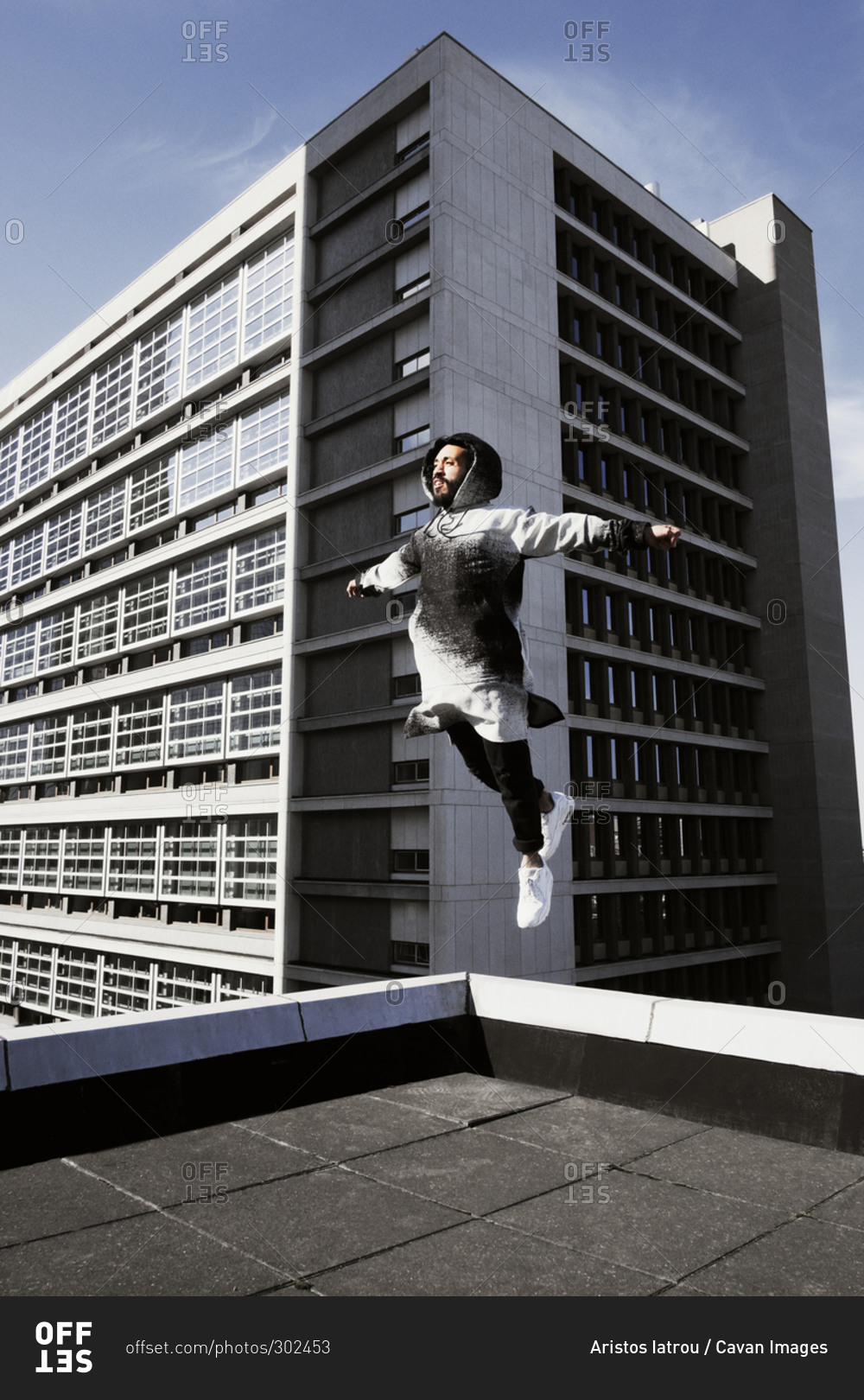 Young man leaping on a rooftop