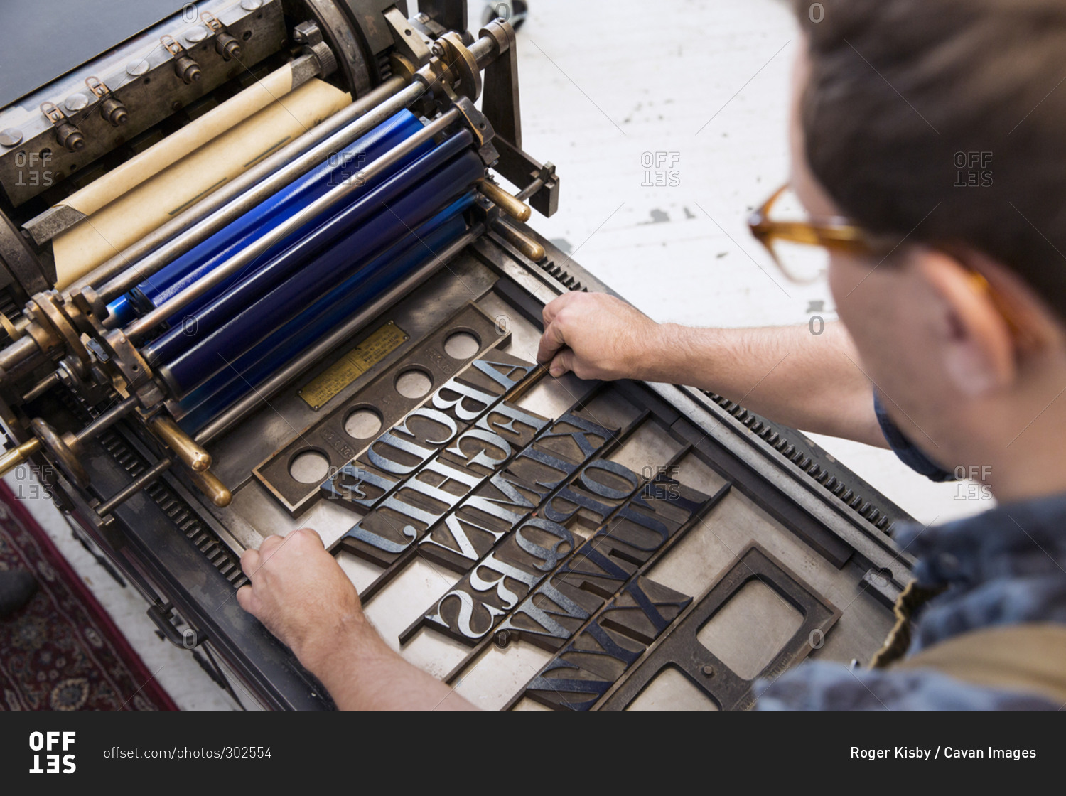 Adjusting type on a letterpress printing press stock photo OFFSET