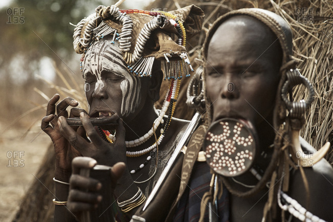 February 20, 2015: Two members of the Mursi tribe standing outside a grass hut