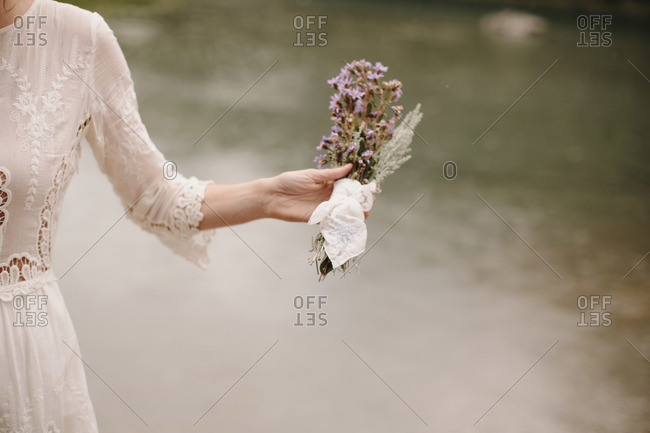 Bride holding bouquet of small purple flowers