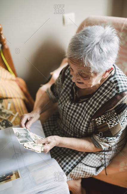 Senior woman looking at old photos of her childhood