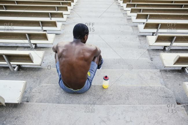 Male athlete sitting on stadium stairs