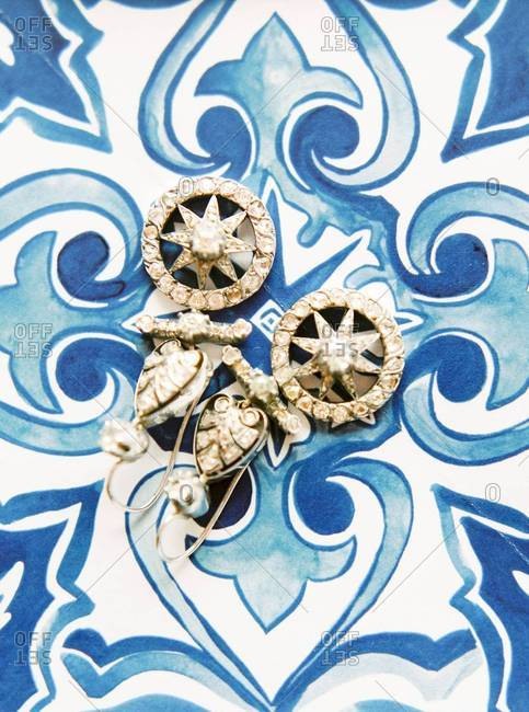 Overhead view of vintage earrings with star motif on tile background