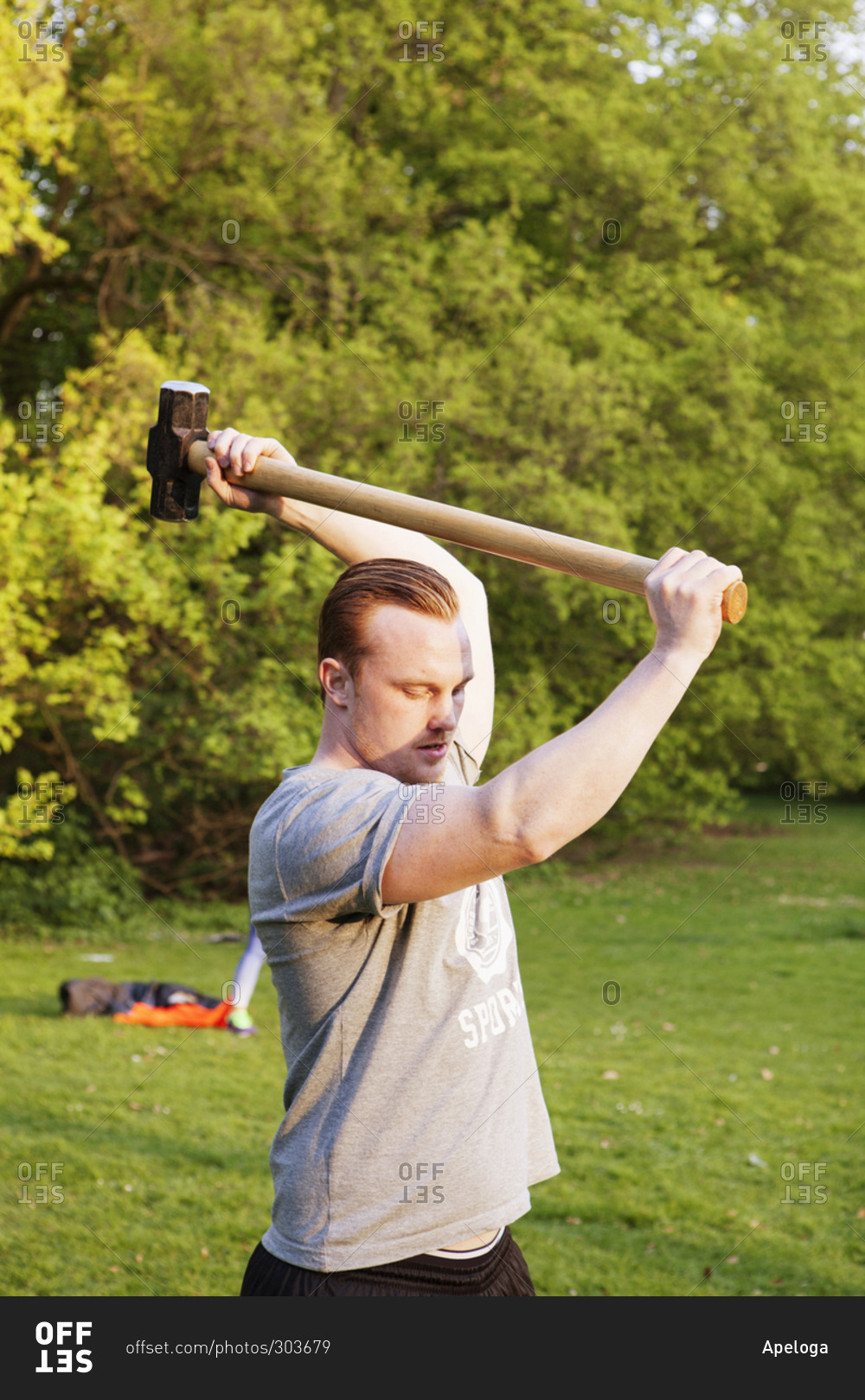 Athletic man lifting a sledge hammer