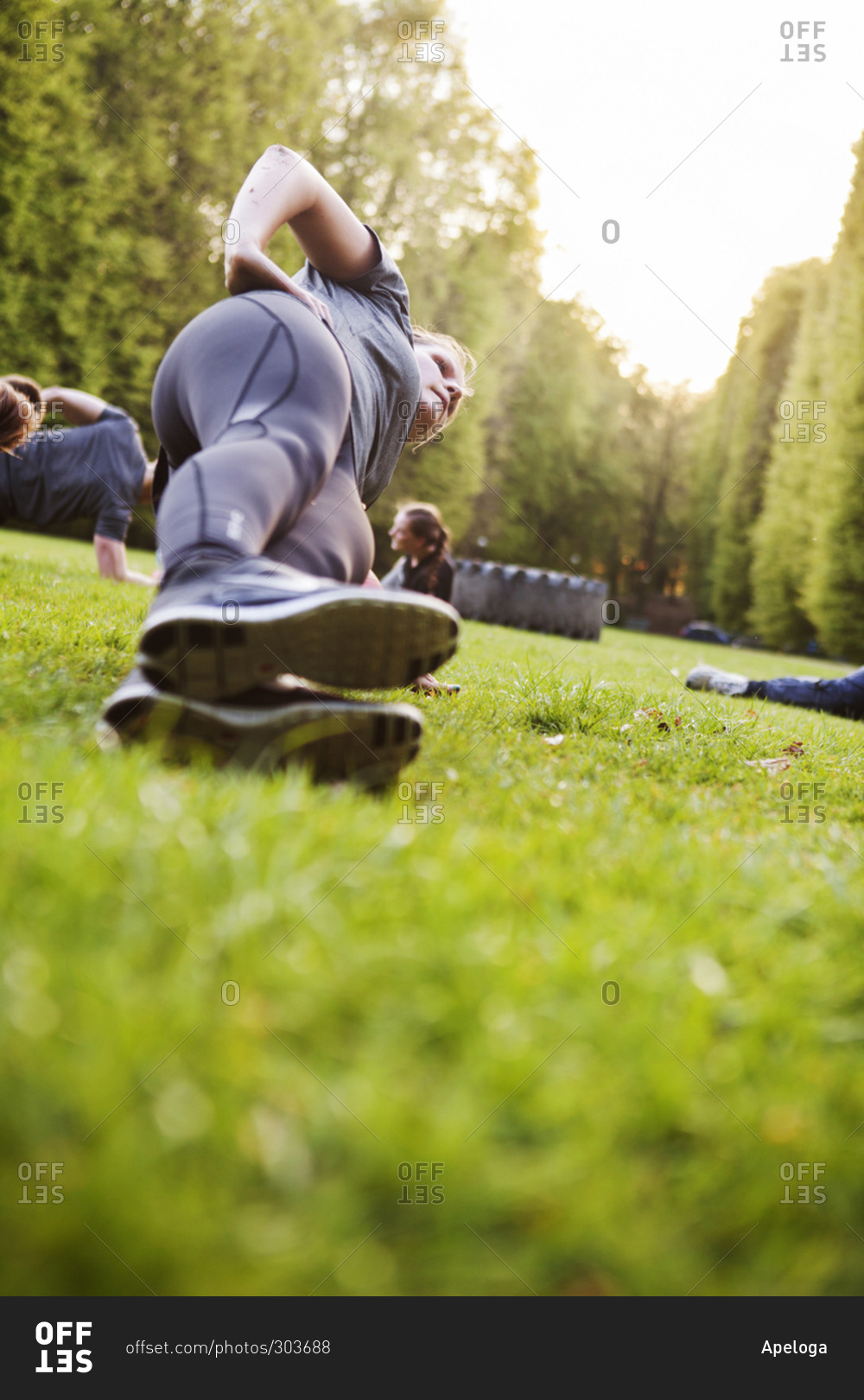 Group of young athletic people working out in the park