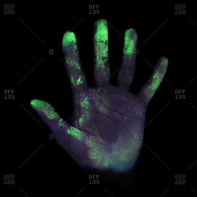 Ultraviolet (UV) light showing bacteria on a person's hand