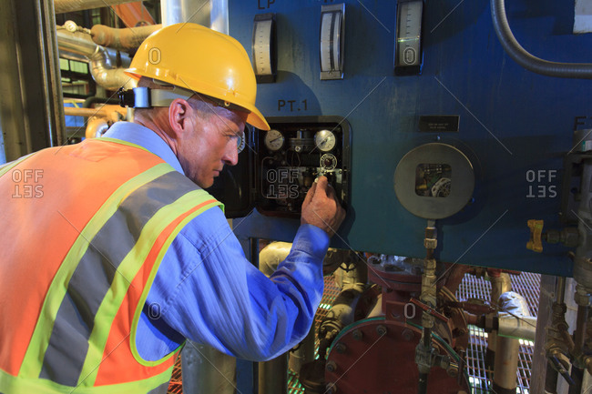 Engineer in electric power plant reviewing sensor readings