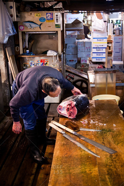 Tsukiji Fish Market - May 5, 2011: Man cutting large fish at the Tsukiji Market