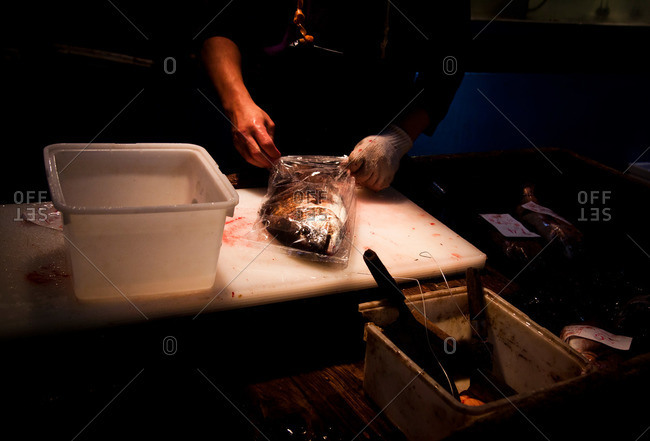 Man placing fish into a bag at the Tsukiji Market