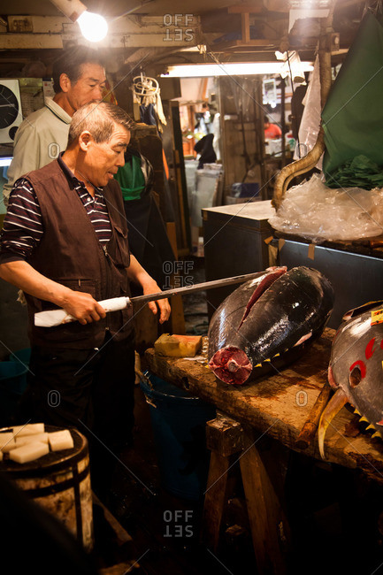 Tsukiji Fish Market - May 5, 2011: Close up of a man cutting large fish at the Tsukiji Market