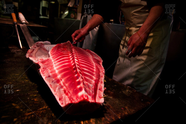 Man cutting fish on a cutting board at the Tsukiji Market