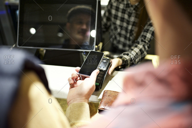 Customer scanning smartphone for payment at concession stand