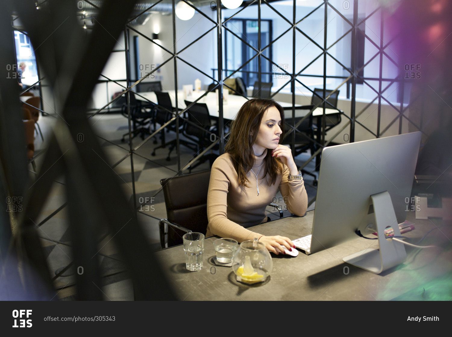 Young woman working in an office with a geometric divider