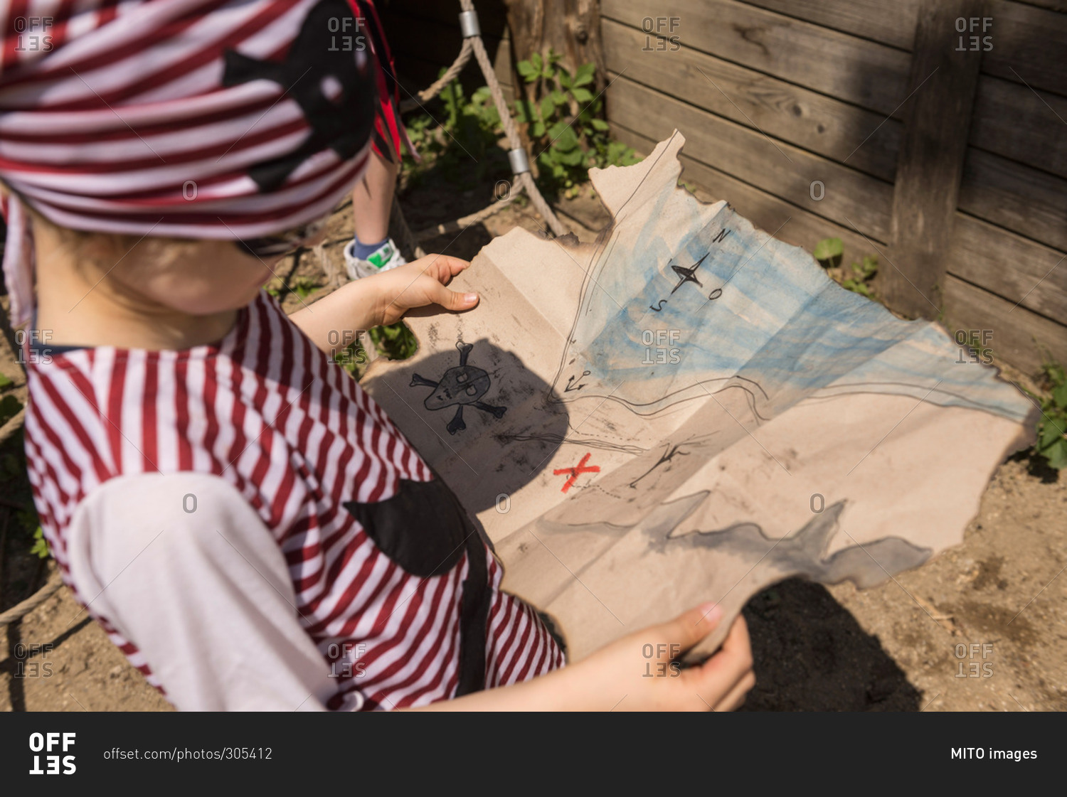 Close-up of a boy examining a treasure map in a adventure playground, Bavaria, Germany