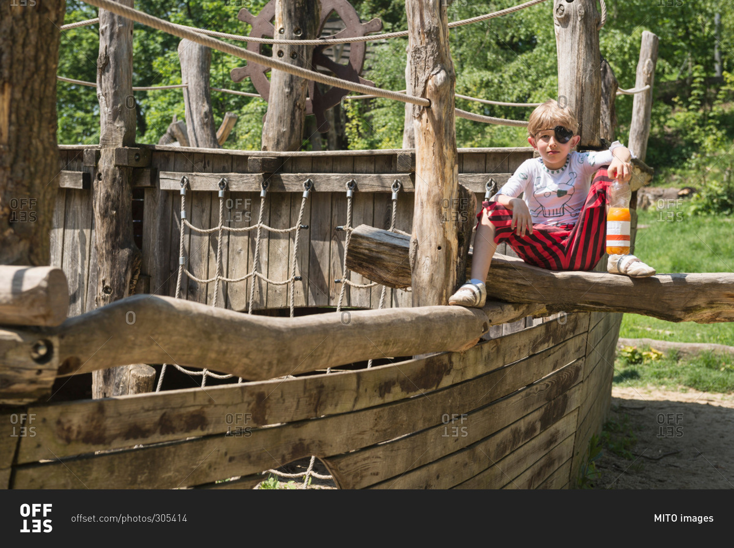 Boy sitting on pirate play ship in adventure playground, Bavaria, Germany