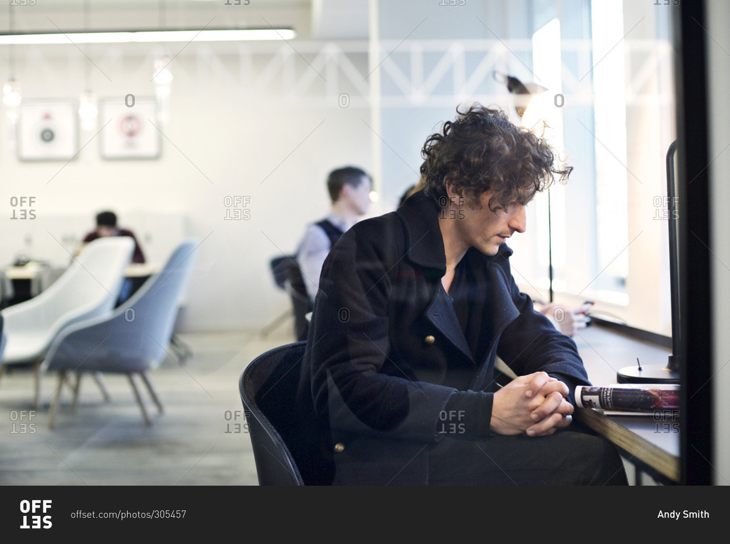 Man reading a magazine at an office work station