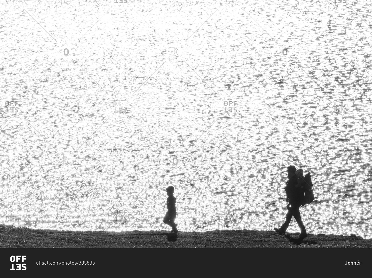 Silhouettes of father with children at sea