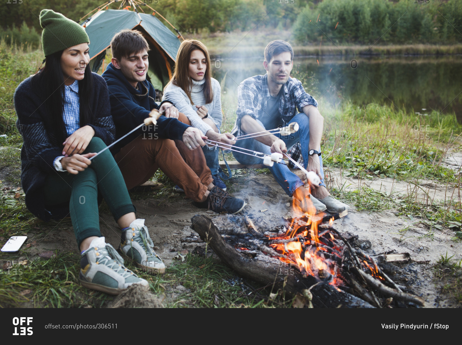 Friends roasting marshmallows in forest