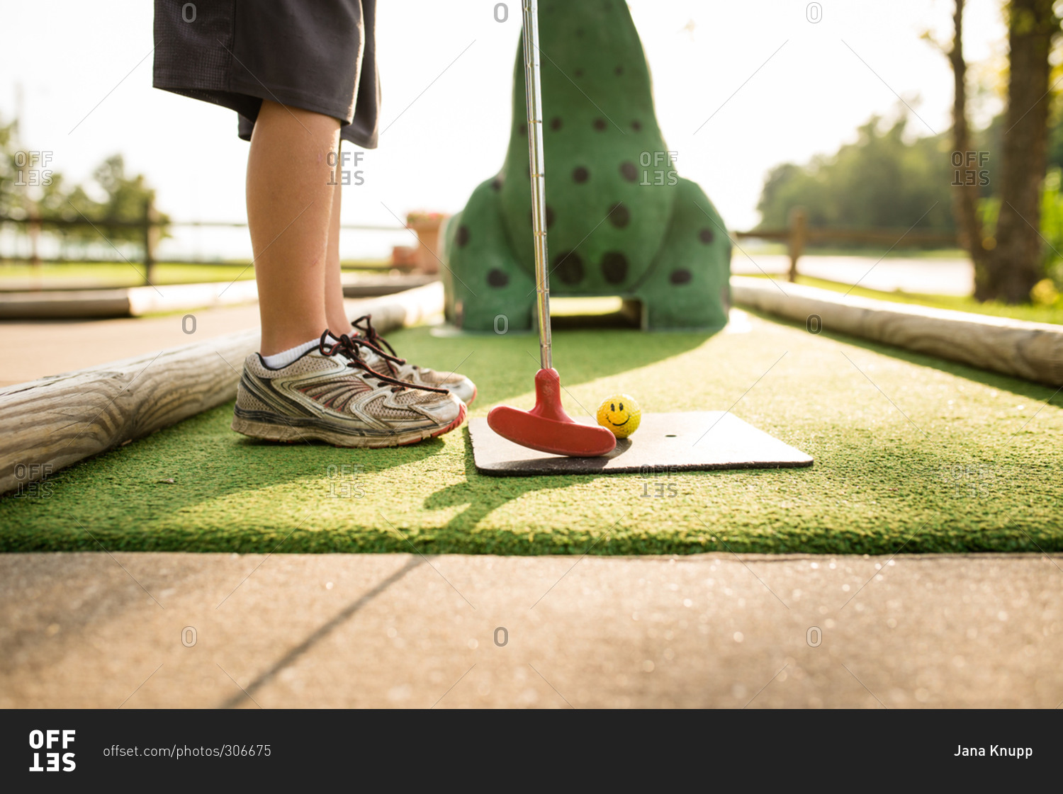 Low section of boy playing mini golf