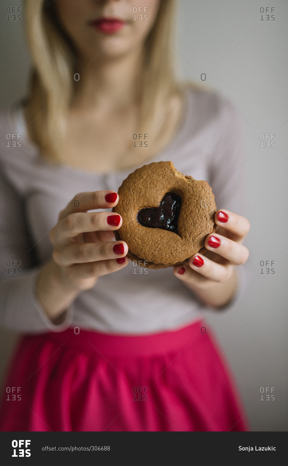 Woman eating a valentine cookie