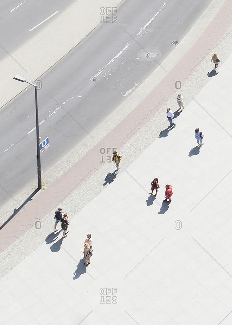 Elevated view of people walking on a sunny sidewalk