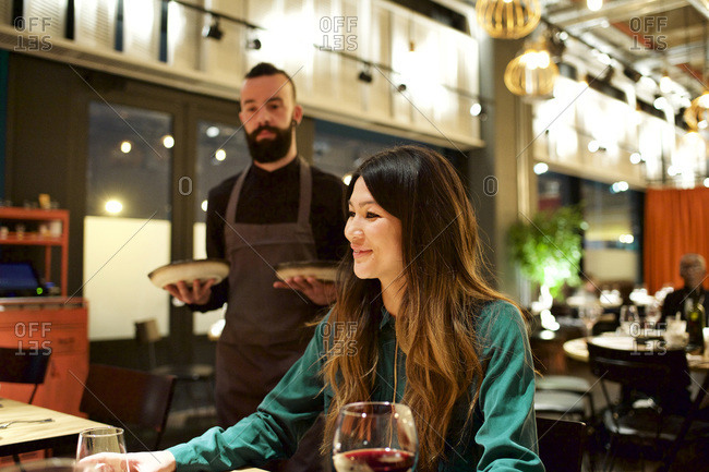 Waiter bringing food to a table in a restaurant