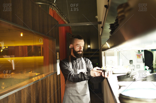 Waiter grabbing food from under a heat lamp