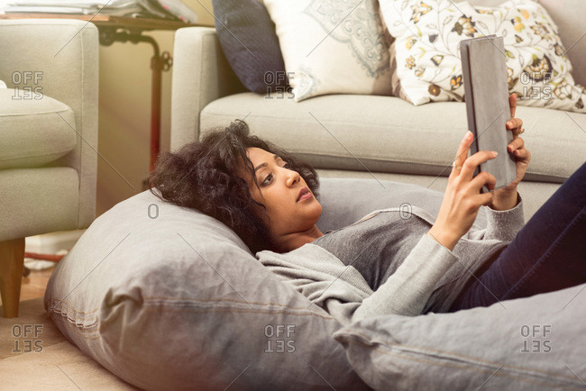Woman on cushions with a tablet