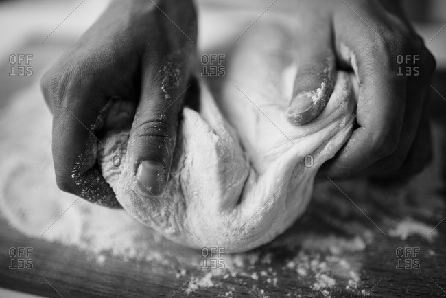 Hands kneading dough in black and white