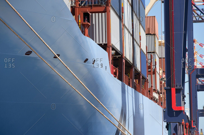 Container ship with cargo containers moored at commercial dock