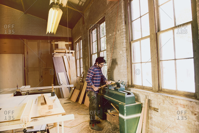 Man shaping a wood piece with machine