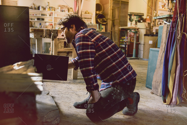 Carpenter putting wood in stove