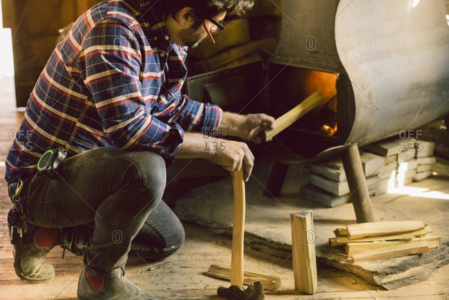 Carpenter putting wood in a stove