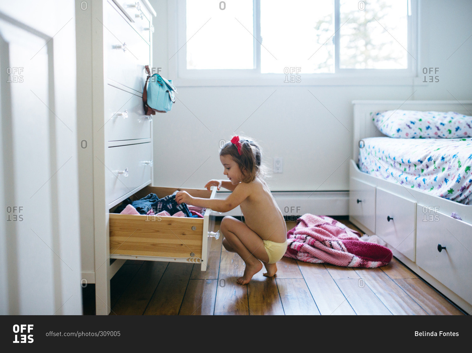 Little girl in her panties picking out what to wear stock photo