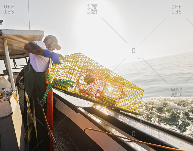 Fishermen throwing lobster trap - Offset
