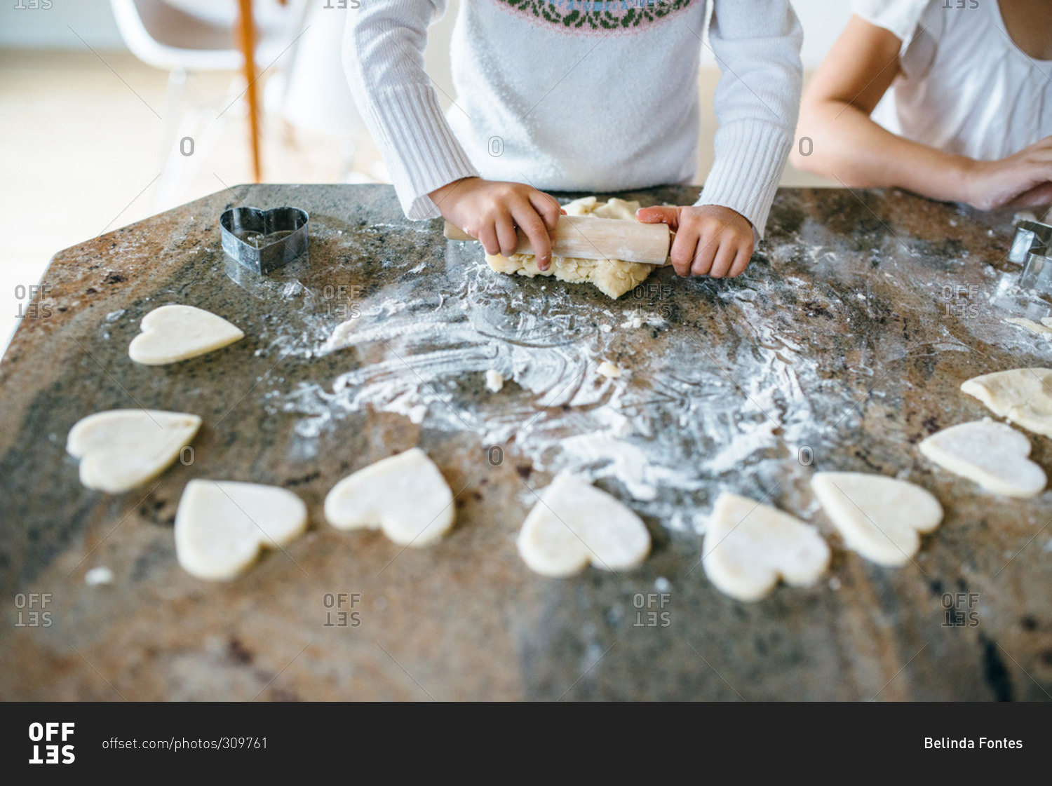 Girl making Valentine heart shaped cookies