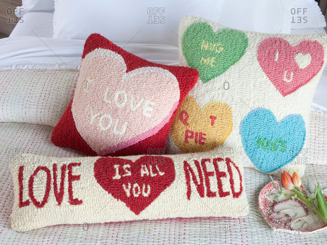Knot Pillows With Romantic Sayings On A Bed Stock Photo Offset