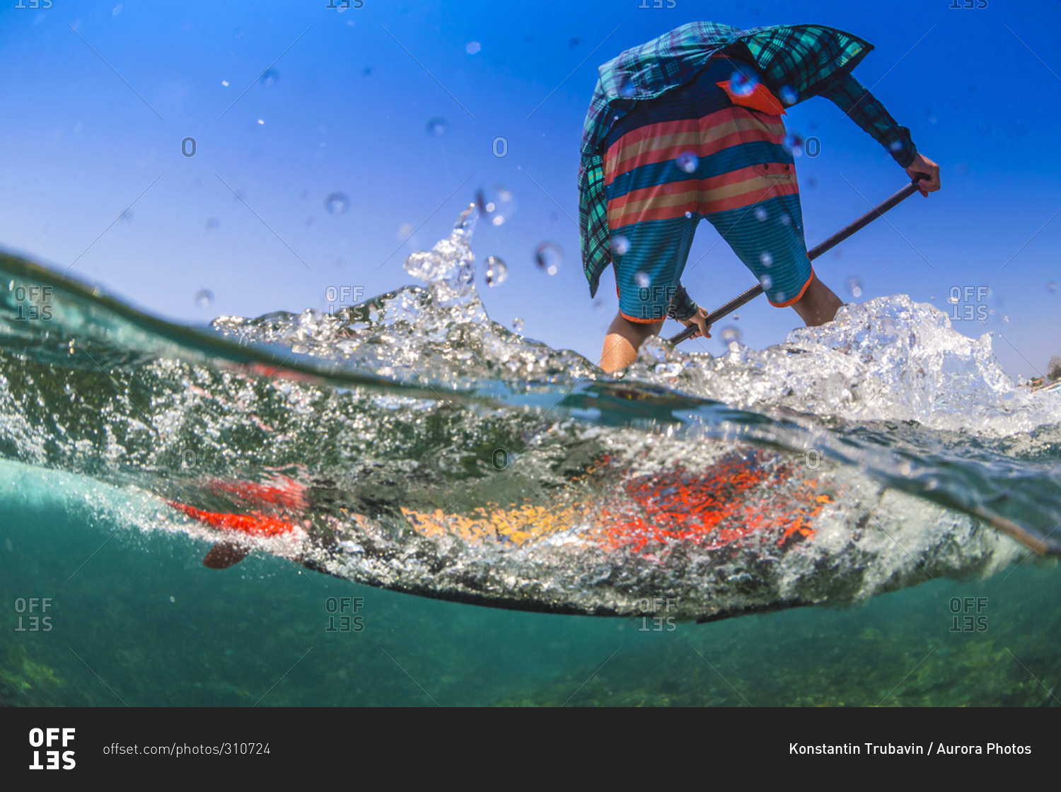 Low angle view of a Sup surfer in tropical water