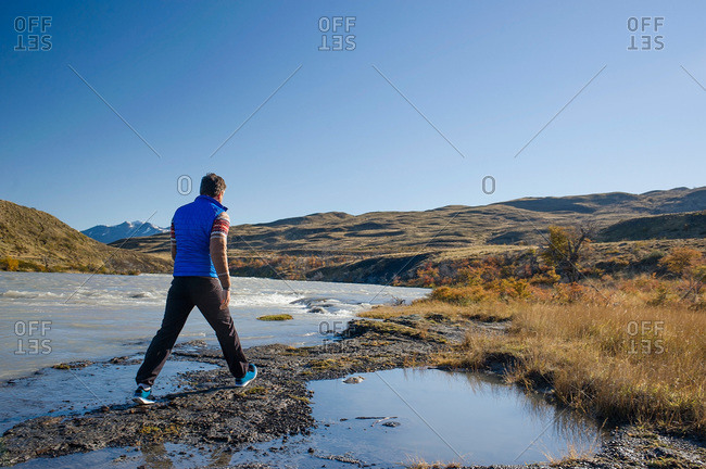Man traversing a stream in Patagonia