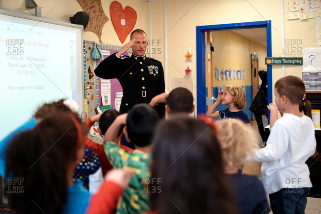 Children saluting a veteran visiting their classroom