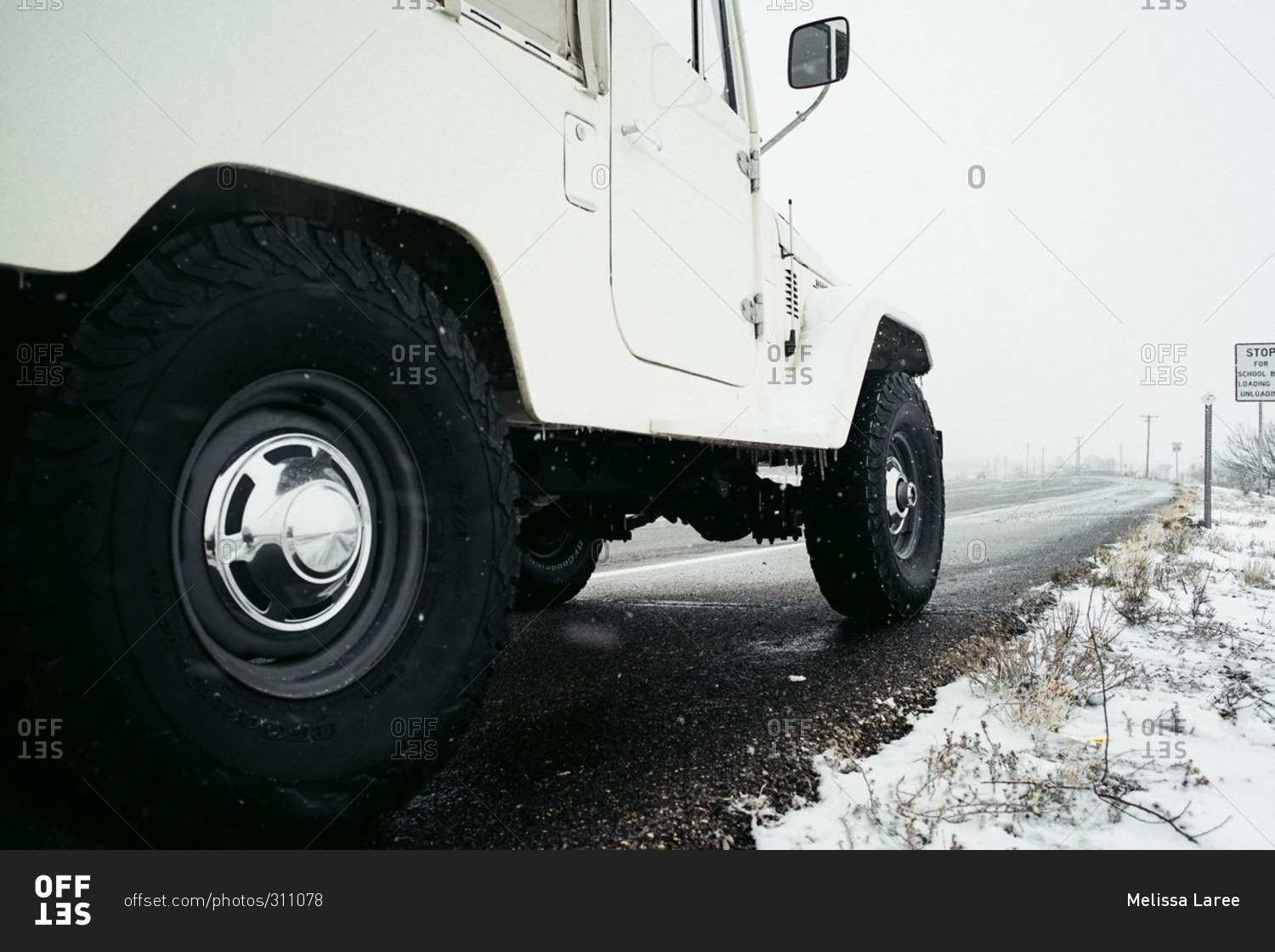 Close-up view of a sports utility vehicle on the side of an icy highway