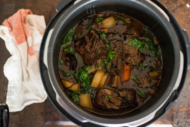 Overhead view braised short ribs with vegetables in pot