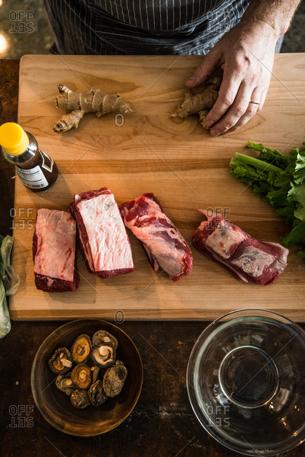 Overhead view of chef preparing short ribs with ginger