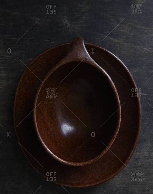 Overhead view of brown pottery dishes on wooden background