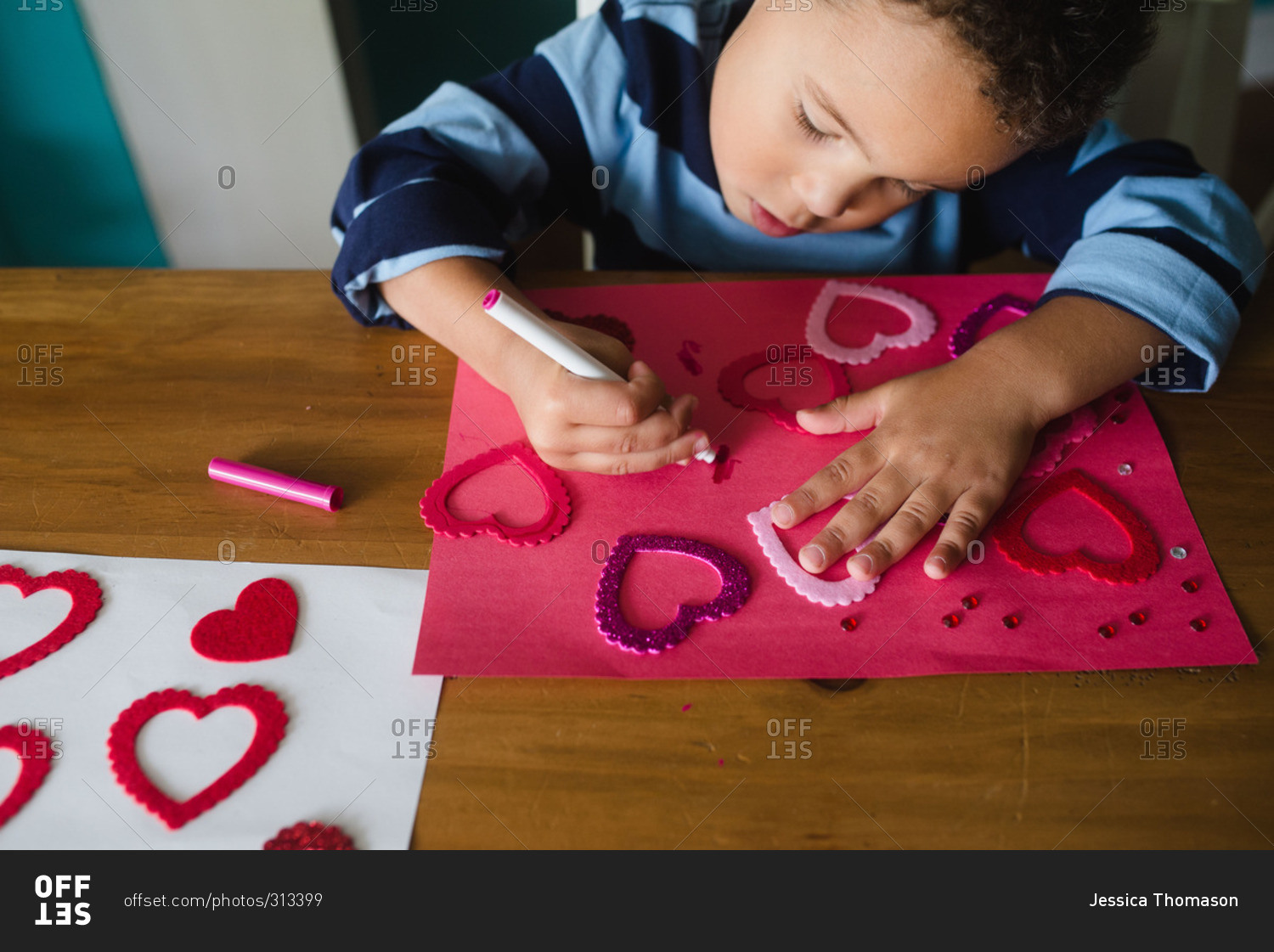 Little boy drawing on a Valentine's Day craft