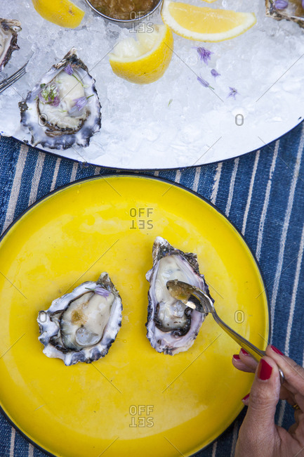 Woman topping her oysters - Offset