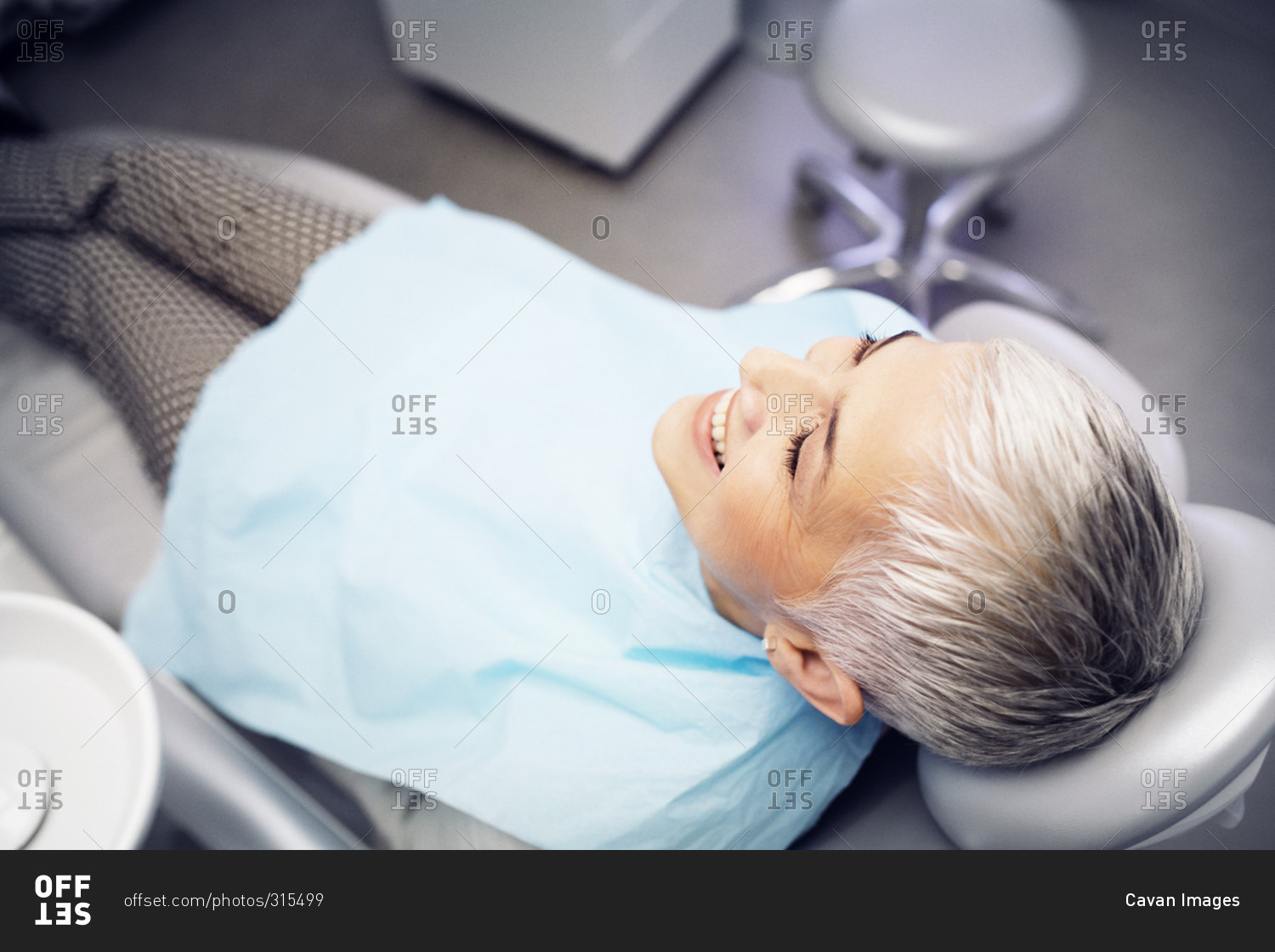 Smiling woman reclining in dentist chair